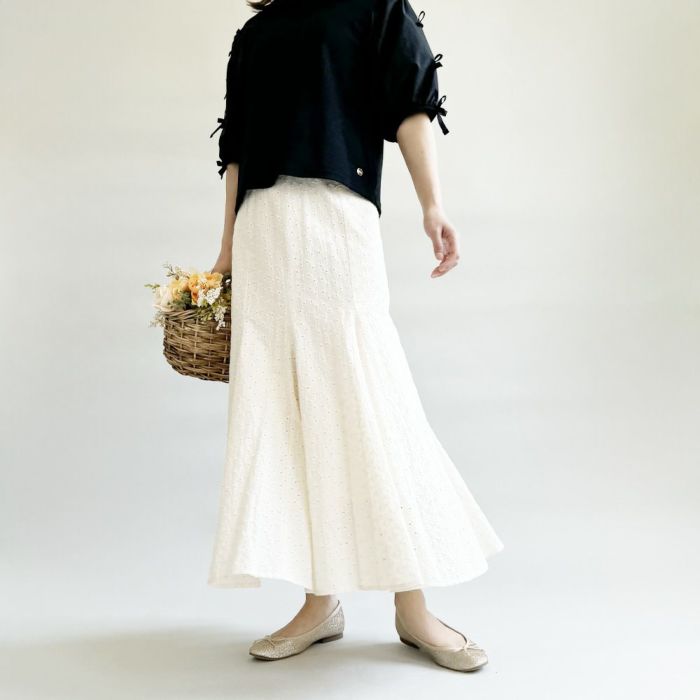 シンプルなブラックとホワイトのスカートに華やかなアクセントをプラス。