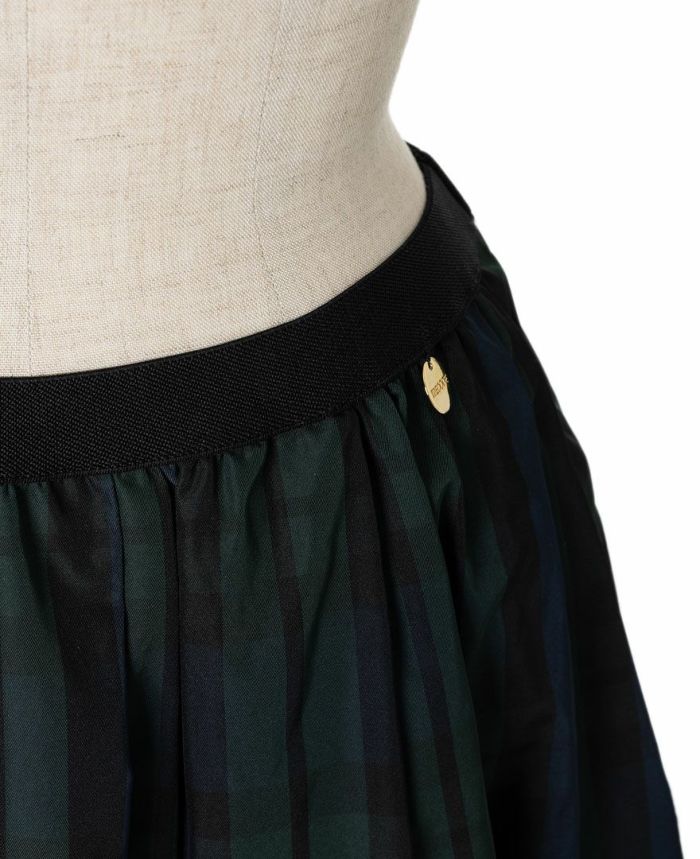 神戸・山の手スカートの左腰には丸いゴールドのオリジナルチャーム付き。