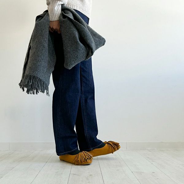 ニット×デニムのシンプルなコーディネートにふさふさのタッセルがアクセサリー代わりのアクセントに。