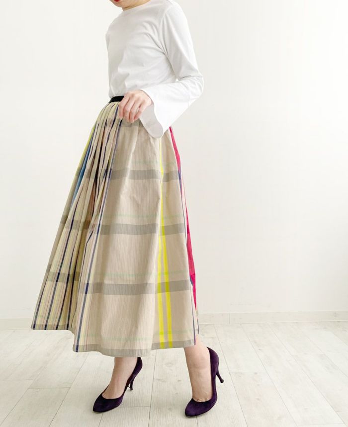 ベルスリーブのカットソーにマキシ丈のスカートのベージュ×ネイビーの柄が見える向きで履いたスタイル