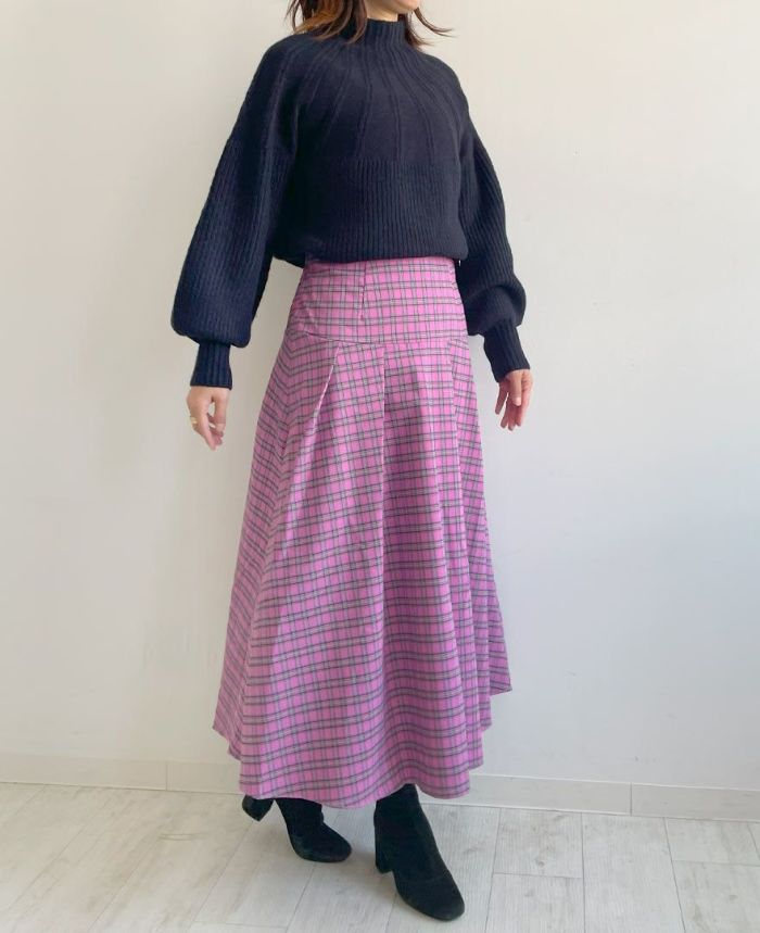 深みのあるブルー味を帯びているピンクのチェック柄スカートにネイビーのメランジキュウシンニットを合わせたぱきっとしたメリハリのあるスタイリング