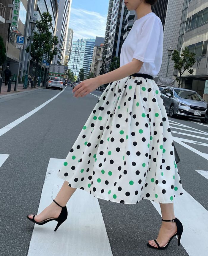 ホワイトのトップスを合わせて爽やかなコーデに。トップスはシンプルなものでも一枚でオシャレにコーデがキマる神戸・山の手グリーンドットスカート。