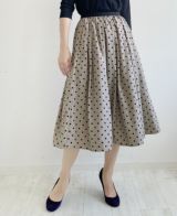 落ち着いたベージュにベルベットのような質感の大きすぎない黒のドット柄が施されているフレアスカート
