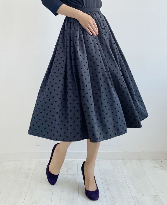 重くなりすぎないダークグレーにベルベットのような質感の大きすぎない黒のドット柄が施されているフレアスカート