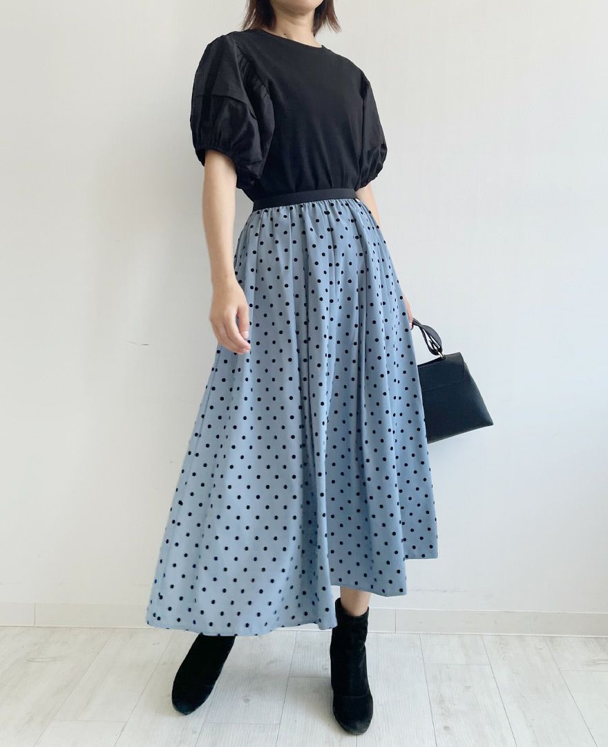 黒のトップスをインして黒のブーツを合わせたシンプルだけど目が惹かれるコーディネート