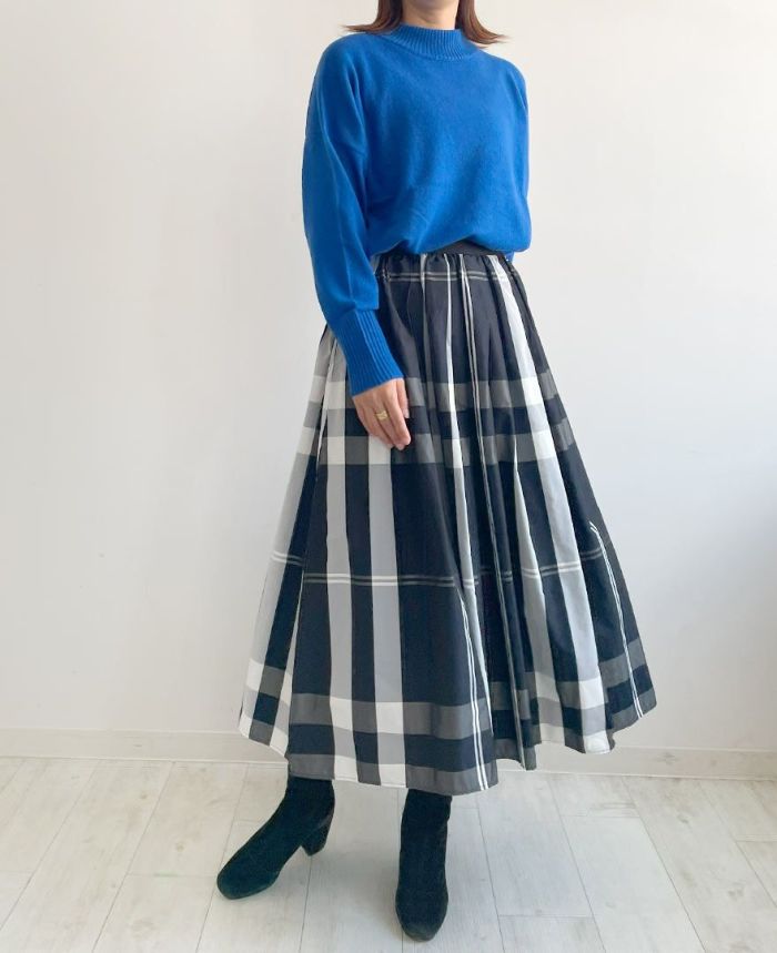鮮やかな青色のアンゴラ混ハイネックニットに紺色ベースのチェック柄スカートをコーディネート。