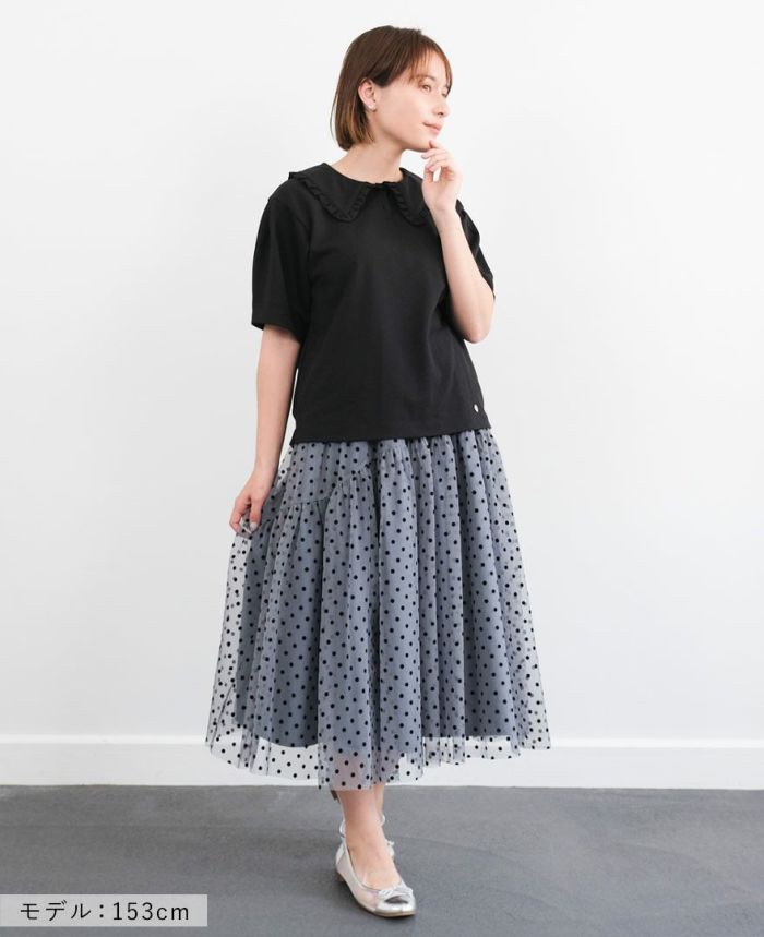ブラックのカノコポロシャツにブルーのドットチュールスカートを合わせたコーディネート