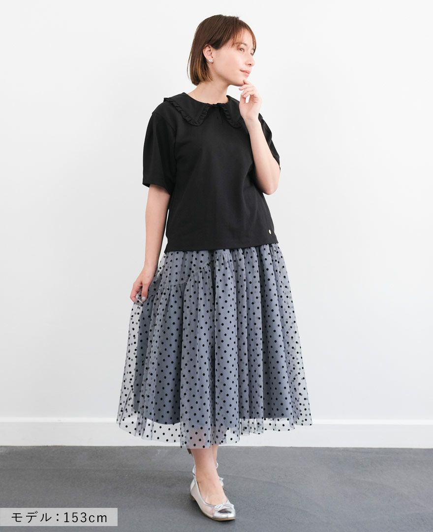 ブラックのカノコポロシャツにブルーのドットチュールスカートを合わせたコーディネート