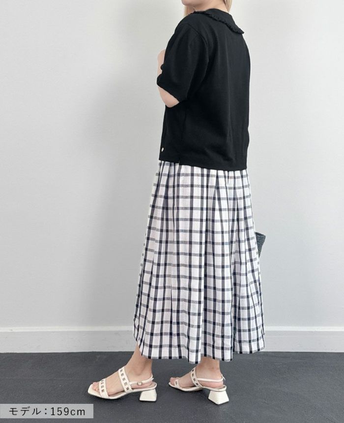 ブラックのカノコポロシャツにネイビーのチェックスカートを合わせたコーディネート