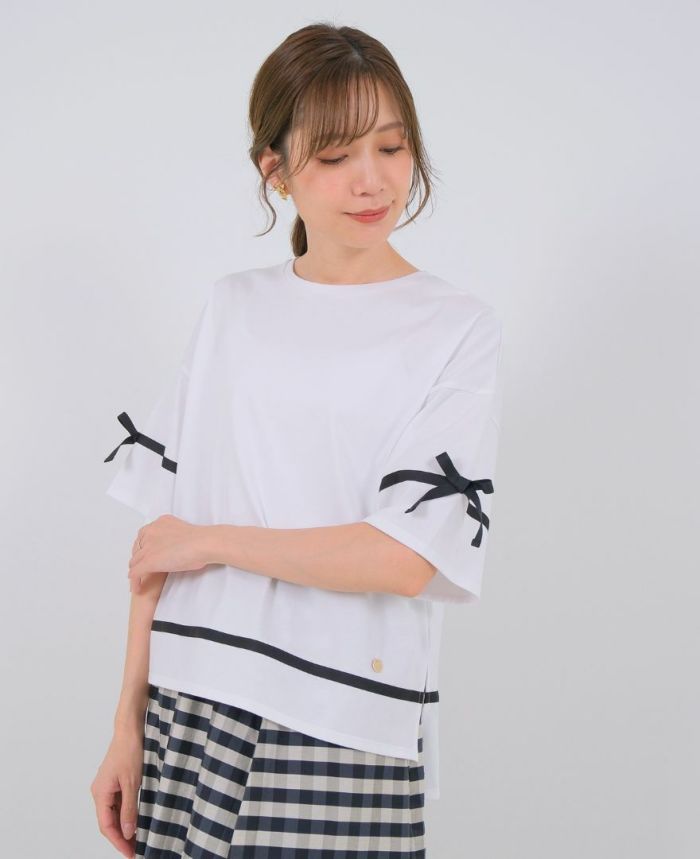 ホワイトのサイドリボンTシャツにブラックのパンツを合わせたコーディネート