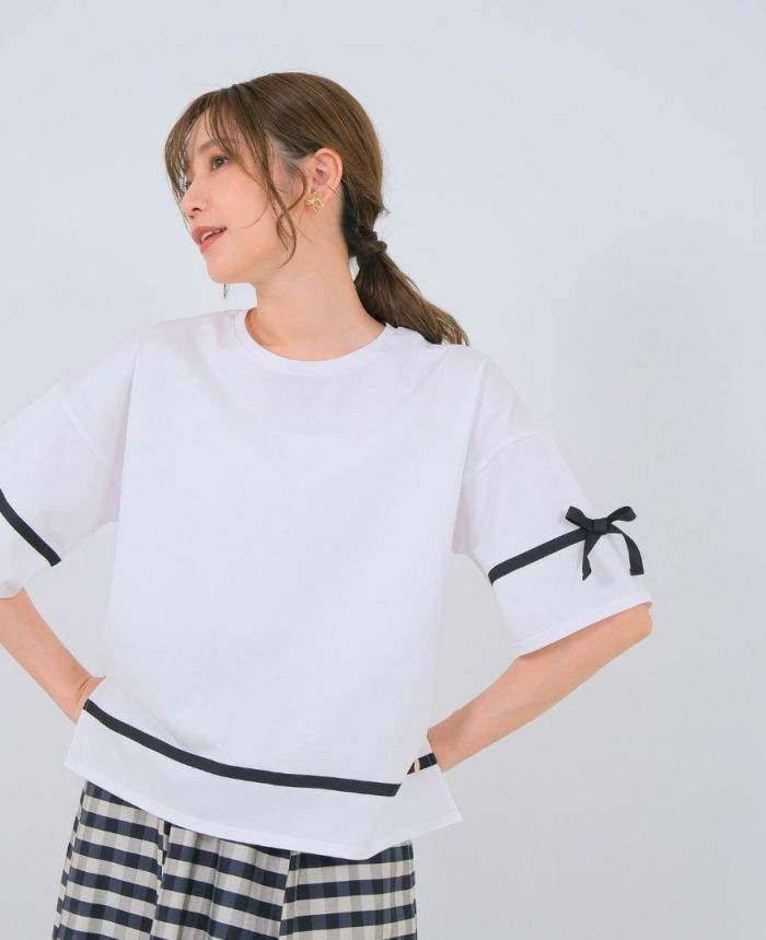 ホワイトのサイドリボンTシャツにブラックのパンツを合わせたコーディネート