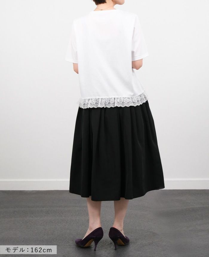 Hワイトの裾レースTシャツにブラックのミモレ丈スカートを合わせたコーディネート画像