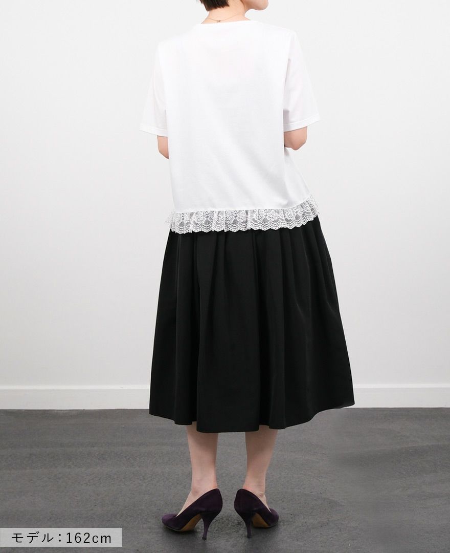 Hワイトの裾レースTシャツにブラックのミモレ丈スカートを合わせたコーディネート画像
