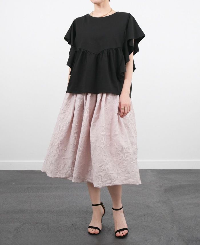 黒のフリルTシャツにペールピンクのスカートを合わせた大人可愛いコーデ